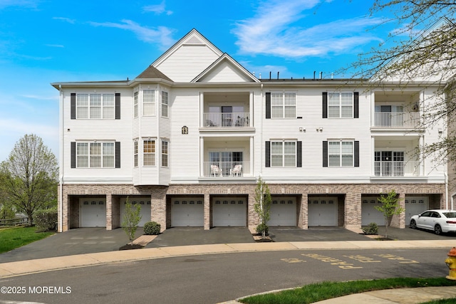 townhome / multi-family property featuring brick siding and a garage