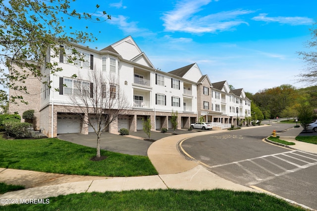 view of building exterior featuring a residential view, driveway, and a garage
