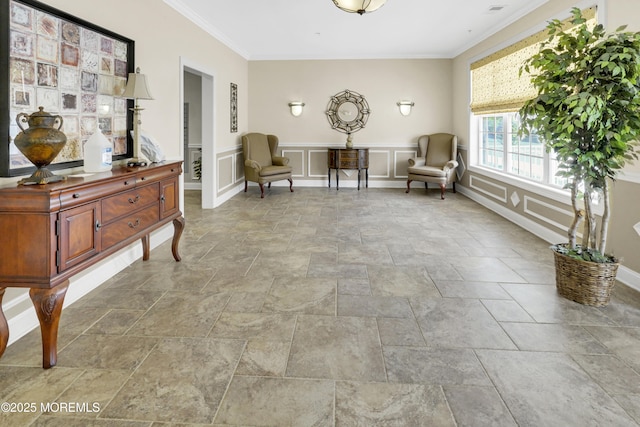 living area featuring crown molding, a decorative wall, and stone tile floors