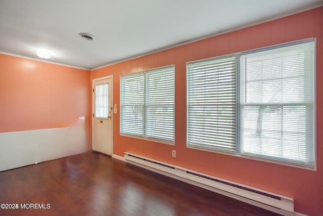 entryway featuring a baseboard radiator, wood finished floors, ornamental molding, and visible vents