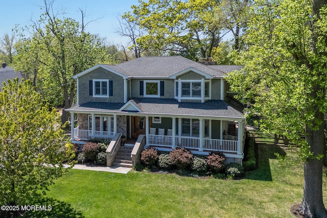 view of front of home with a porch, a front lawn, roof with shingles, and stone siding
