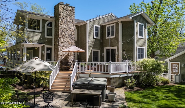 back of house with a wooden deck, stairs, a patio area, and a chimney