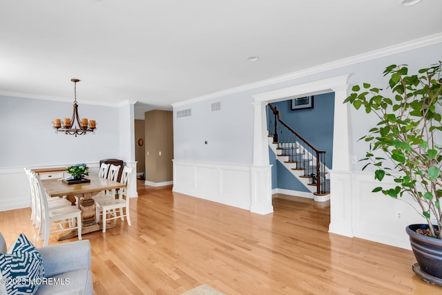 living area featuring an inviting chandelier, ornamental molding, and visible vents