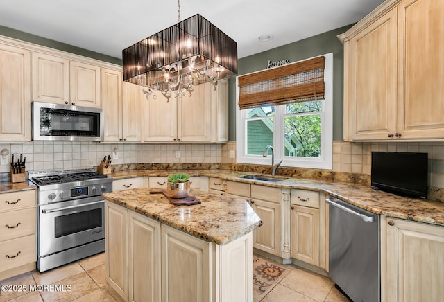 kitchen featuring a sink, appliances with stainless steel finishes, light tile patterned floors, and a chandelier