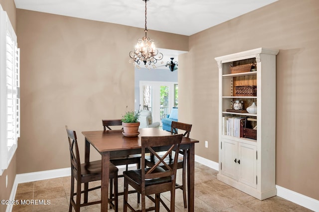 dining area with an inviting chandelier and baseboards