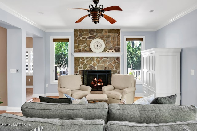 living room with ceiling fan, a stone fireplace, a healthy amount of sunlight, and wood finished floors