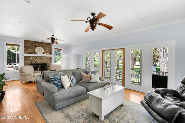 living area featuring a ceiling fan, plenty of natural light, and light wood finished floors