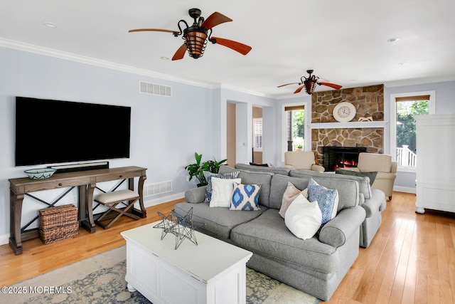living room featuring plenty of natural light, a ceiling fan, light wood finished floors, and visible vents