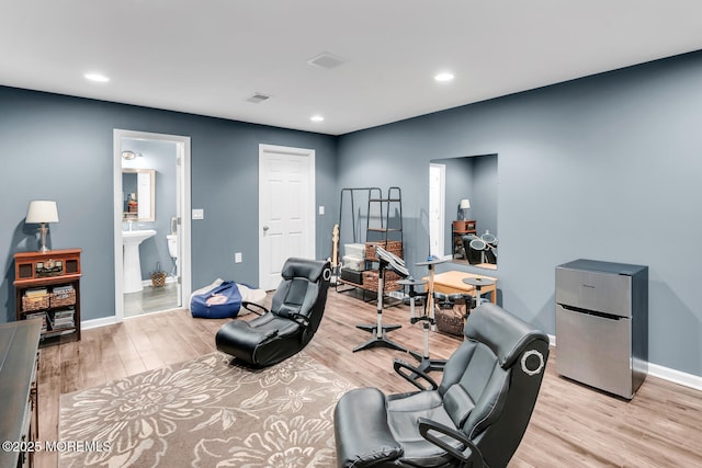 exercise room featuring light wood-style floors, recessed lighting, and baseboards