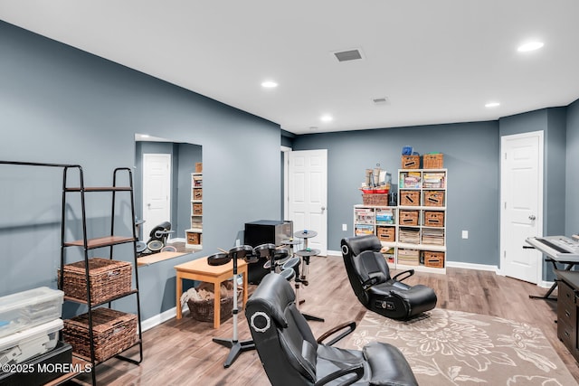 workout room featuring baseboards, recessed lighting, and wood finished floors