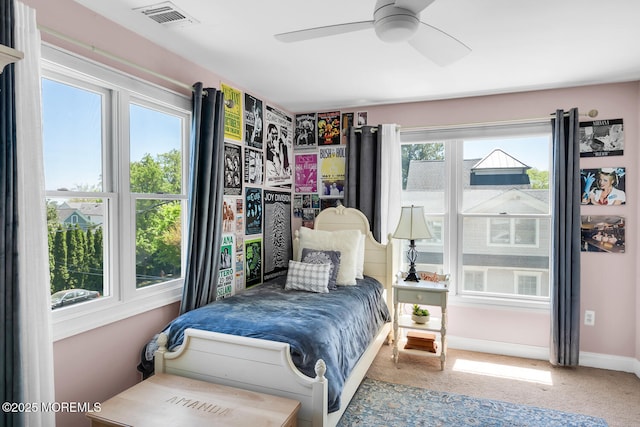 carpeted bedroom with visible vents, baseboards, and ceiling fan