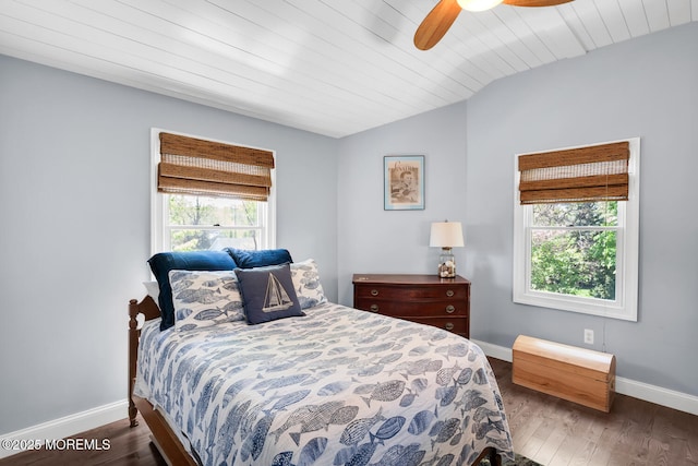 bedroom with baseboards, vaulted ceiling, and wood finished floors