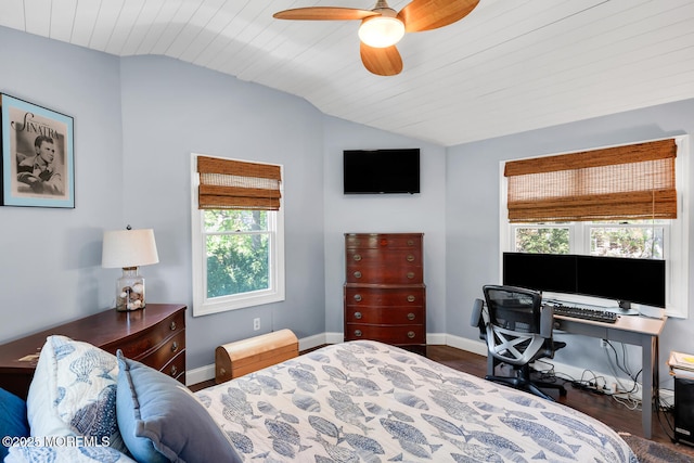 bedroom with baseboards, multiple windows, wood finished floors, and lofted ceiling