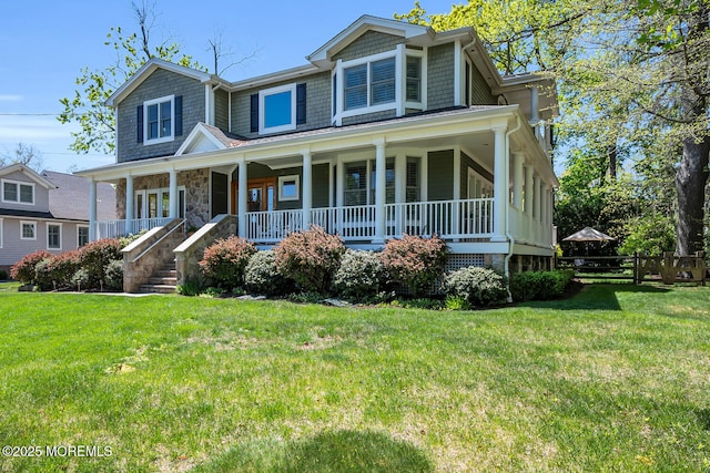 view of front of property with covered porch, fence, and a front yard