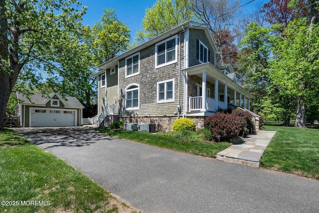 view of home's exterior featuring a garage, a yard, an outbuilding, and cooling unit