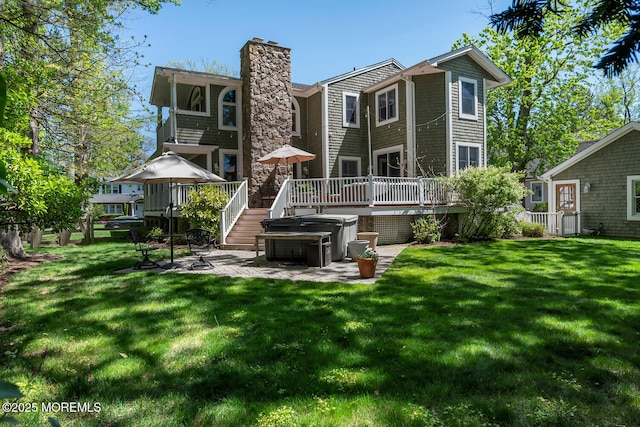 back of house with a wooden deck, a chimney, a yard, and a patio area