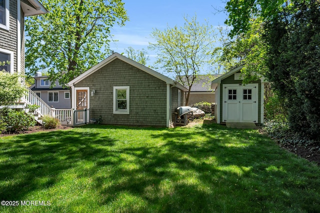 back of property with a lawn, an outbuilding, and a storage unit