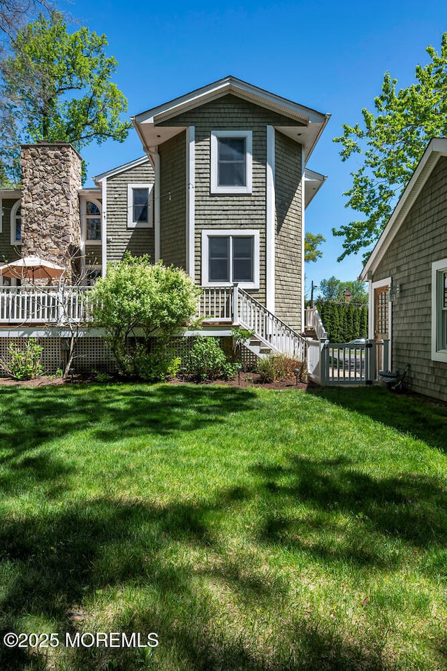 rear view of house featuring a lawn