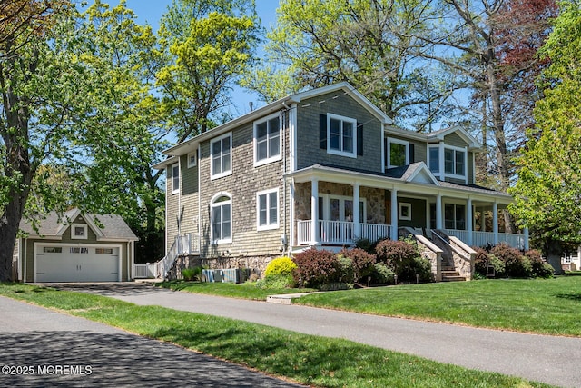 view of front of house with covered porch, stone siding, a detached garage, a front yard, and an outdoor structure