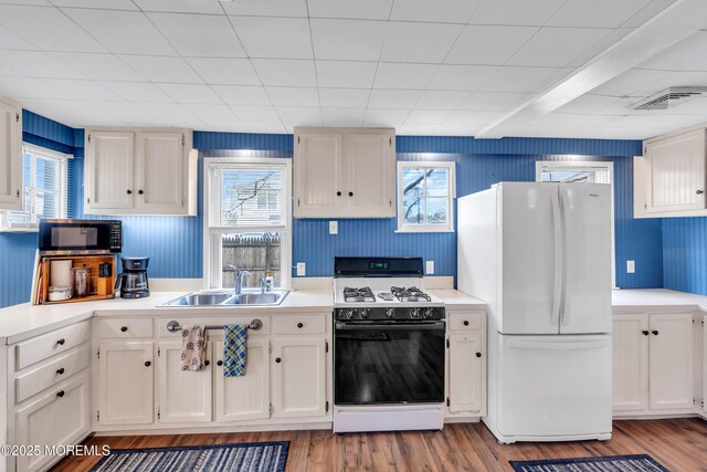 6 Beachwood Blvd, Beachwood, NJ 08722 - kitchen featuring stainless steel microwave, freestanding refrigerator, white cabinets, gas range, and a sink