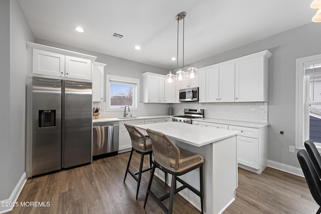 211 Pine Dr, Bayville, NJ 08721 - kitchen featuring visible vents, a sink, dark wood-style flooring, appliances with stainless steel finishes, and decorative backsplash