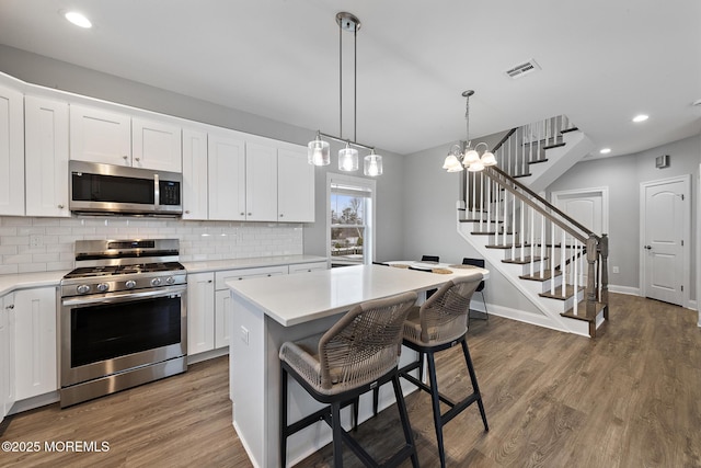 211 Pine Dr, Bayville, NJ 08721 - kitchen with white cabinetry, visible vents, light countertops, stainless steel appliances, and backsplash