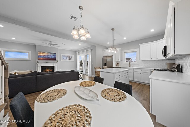 211 Pine Dr, Bayville, NJ 08721 - dining room featuring visible vents, a ceiling fan, recessed lighting, wood finished floors, and a lit fireplace