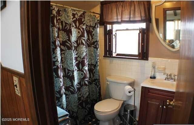 319 Main St, Avon-By-The-Sea, NJ 07717 - full bath with vanity, curtained shower, a wainscoted wall, toilet, and tile walls