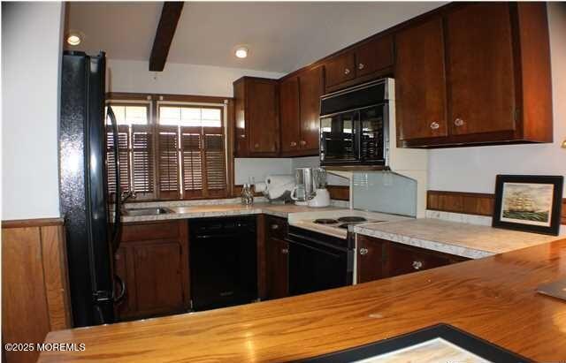 319 Main St, Avon-By-The-Sea, NJ 07717 - kitchen with dark brown cabinetry, a sink, black appliances, and wooden counters