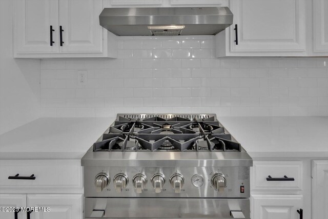 101 Torrey Pines Dr, Toms River, NJ 08757 - room details with range hood, light countertops, stainless steel range with gas cooktop, white cabinetry, and backsplash