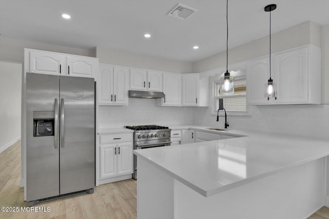 101 Torrey Pines Dr, Toms River, NJ 08757 - kitchen with a peninsula, under cabinet range hood, visible vents, stainless steel appliances, and a sink