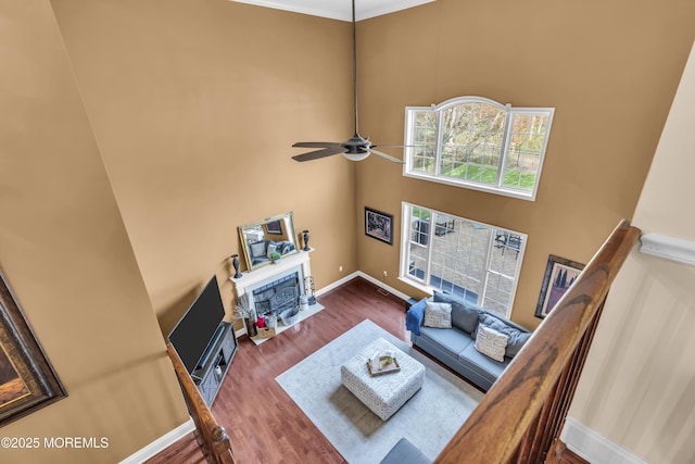 41 Hedgerow Ln, Manalapan, NJ 07726 - living room featuring a towering ceiling, baseboards, a ceiling fan, wood finished floors, and a fireplace