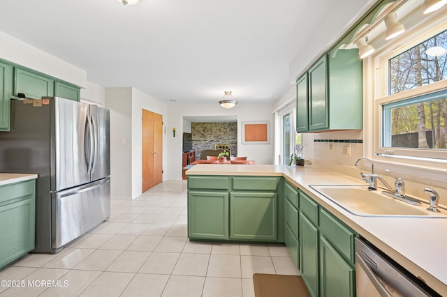 kitchen with plenty of natural light, green cabinets, and appliances with stainless steel finishes