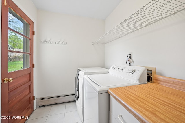 laundry area with baseboard heating, washer and dryer, laundry area, and light tile patterned floors