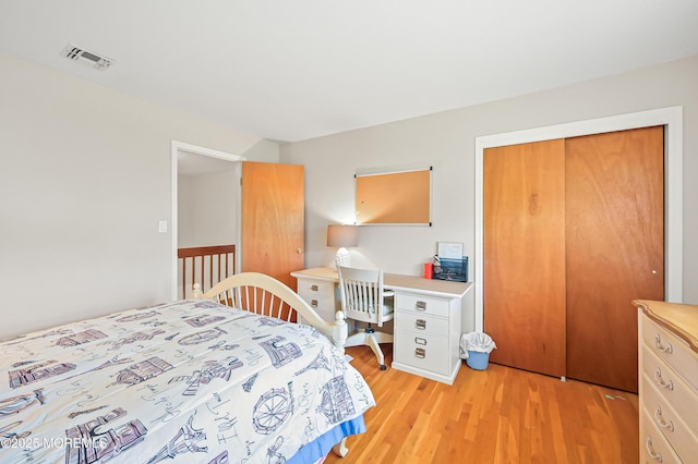 bedroom with light wood finished floors and visible vents