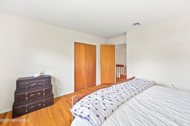 bedroom featuring a closet, wood finished floors, and visible vents
