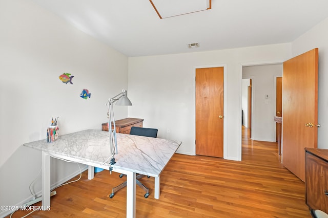 office with baseboards, light wood-style floors, and visible vents