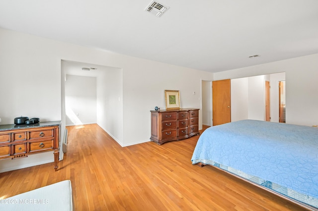 bedroom featuring light wood-type flooring, baseboards, and visible vents