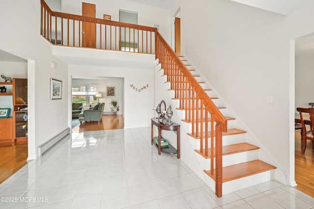 stairs featuring a baseboard heating unit and tile patterned flooring