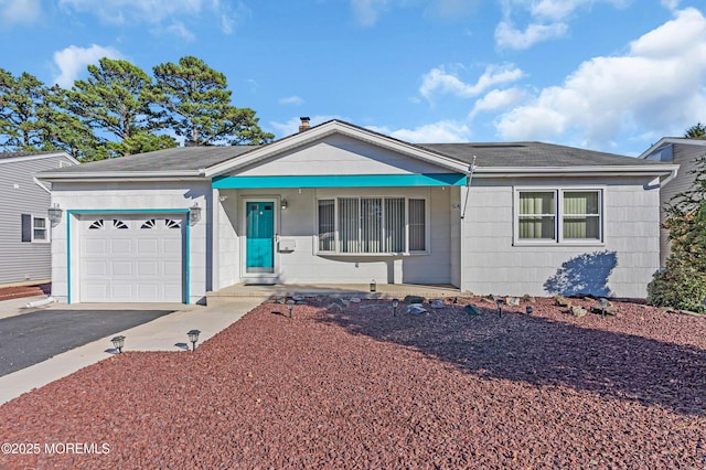 single story home featuring aphalt driveway and a garage