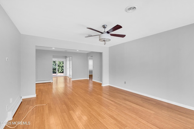 spare room with a baseboard radiator, light wood-type flooring, visible vents, and a ceiling fan