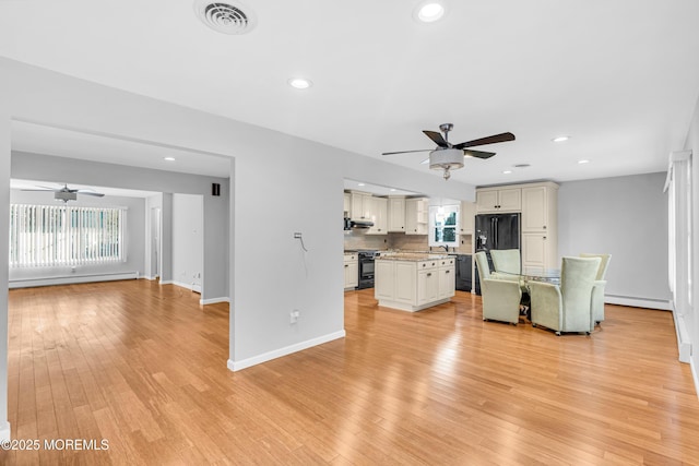 unfurnished living room with a baseboard radiator, a healthy amount of sunlight, and ceiling fan
