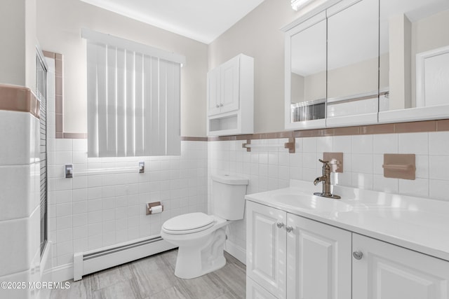 bathroom with an enclosed shower, toilet, vanity, wainscoting, and a baseboard radiator