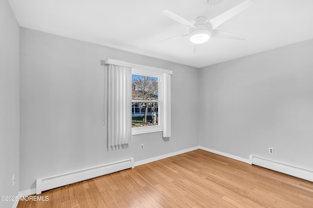 empty room featuring a baseboard radiator, baseboards, wood finished floors, and ceiling fan