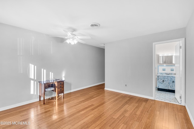 unfurnished living room with light wood-style floors, visible vents, a ceiling fan, and baseboards