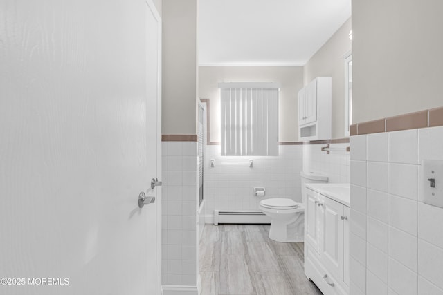 bathroom featuring toilet, tile walls, wainscoting, baseboard heating, and walk in shower