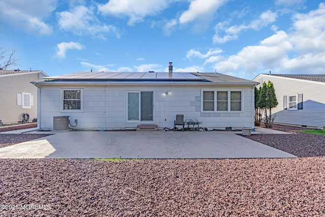 back of property featuring roof mounted solar panels, a patio, and central AC unit