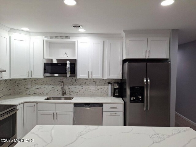 kitchen with tasteful backsplash, open shelves, a sink, stainless steel appliances, and white cabinets
