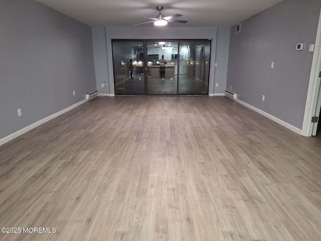 interior space featuring wood finished floors, visible vents, baseboards, and ceiling fan