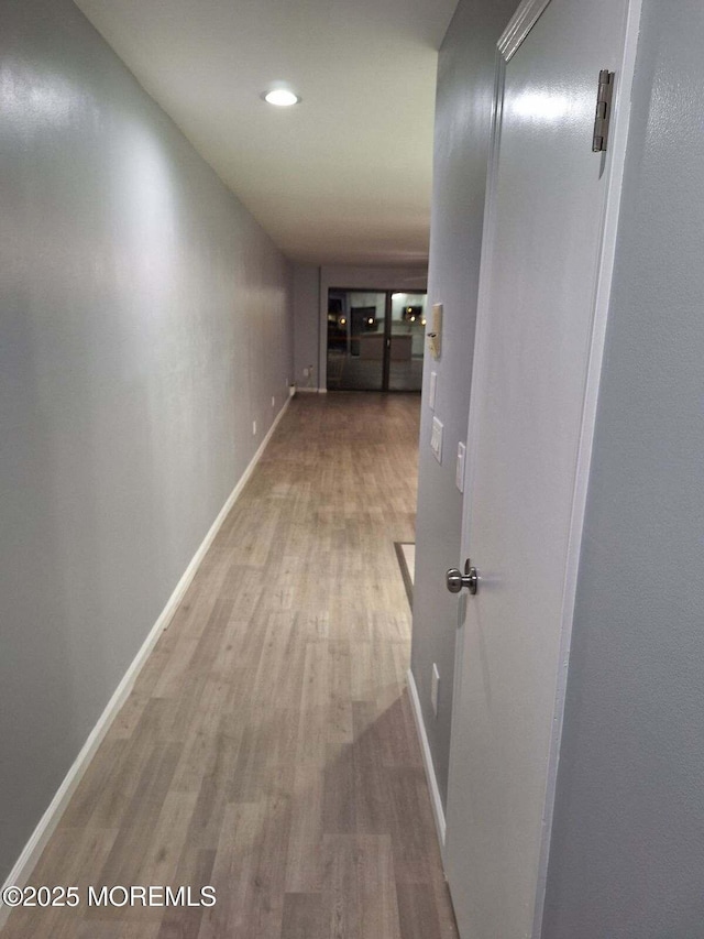 corridor featuring recessed lighting, wood finished floors, and baseboards